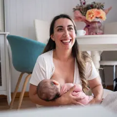 Szczęśliwa mama karmi piersią dziecko, pokazując jedną z wielu zalet karmienia piersią.