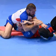 Dwóch mężczyzn walczy na macie. Jeden klęczy, drugi leży. To właśnie bjj co to za sport?