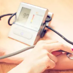 Pomiar ciśnienia krwi za pomocą ciśnieniomierza. Dłoń z pompką i stetoskopem, ekran z wynikiem 97. Dbanie o zdrowie z Primacor.