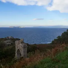 Ruinas de un antiguo faro silleiro, con el mar azul y las islas Cíes al fondo.
