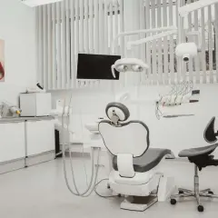 Nowoczesny gabinet stomatologiczny z fotelem dentystycznym, lampą i obrazem ust.