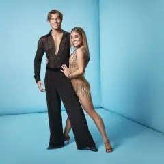 Lets dance deltagare redo för dansgolvet. Han i svart skjorta med stenar, hon i glittrig gul klänning.