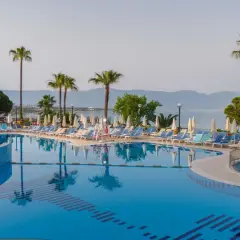 Basen z leżakami i palmami, idealne miejsce na wakacje w Fantasia De Luxe Kusadasi.
