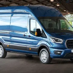 Niebieski Ford Transit zaparkowany pod zadaszeniem, widok z przodu i z boku.