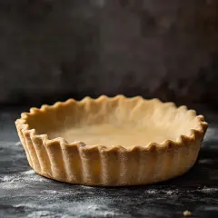 En tom, gyllene matpaj med vågiga kanter står redo att fyllas med läckerheter.