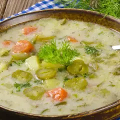 Zupa ogórkowa z ziemniakami i marchewką, ozdobiona koperkiem. Pamiętaj, jakiej przyprawy nie wolno dodawać do zupy ogórkowej, by nie zepsuć jej smaku!