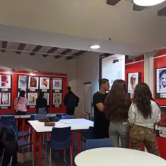 Visitantes observan obras en una exposición en el centro cultural Ramón Pelayo.