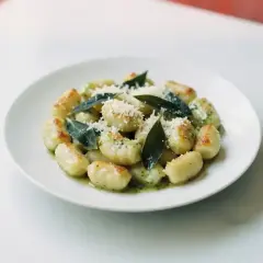 Pyszne gnocchi z sosem, posypane parmezanem i ozdobione listkami szałwii. Idealne danie dla miłośników włoskich smaków.