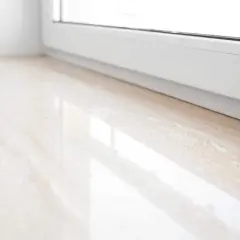 Jasny parapet z konglomeratu, z subtelnymi żyłkami, odbija światło. Wybór między parapetem mdf czy konglomerat jest ważny dla estetyki wnętrza.