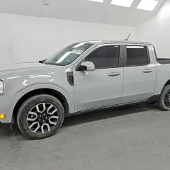 Szary Ford Maverick, kompaktowy pickup, stoi w garażu. Jego linia nadwozia jest nowoczesna, a przednie światła LED nadają mu charakterystyczny wygląd.