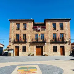 Ayuntamiento de ladrillo en plaza soleada, ideal para descubrir pueblos con encanto para comer cerca de Madrid.