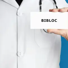 Lekarz w białym kitlu trzyma kartkę z napisem "BIBLOC". To nazwa handlowa leku bisoprolol, stosowanego w leczeniu chorób serca.