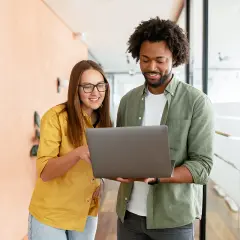A woman and man discuss public administration vs public policy on a laptop.