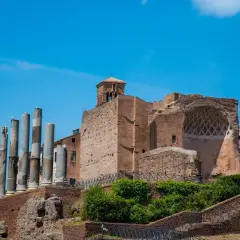 Resti antichi a Roma, tra cui colonne e mura di mattoni, evocano la grandezza della Domus Aurea.