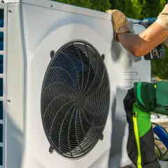 Technik w rękawiczkach dokręca śrubę w pompie ciepła. Dowiedz się, jak zmniejszyć ciśnienie w pompie ciepła, by zapewnić jej prawidłowe działanie.