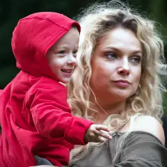 Joanna Liszowska z dziećmi, uśmiechnięty chłopiec w czerwonej bluzie na rękach mamy.