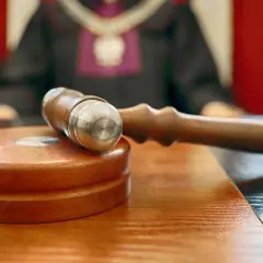 Młotek sędziowski na stole. Sąd rozstrzyga, czy odpowiedź na apelację doręcza się bezpośrednio pełnomocnikowi.