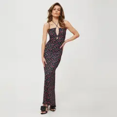 Kobieca sukienka maxi w drobne czerwone kwiatki, idealna do letnich stylizacji. Dekolt typu halter i wycięcie dodają jej charakteru.