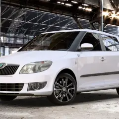 Biała Skoda Fabia z czarnymi felgami stoi w opuszczonej hali. Rozmiar opon idealnie pasuje do sportowego charakteru auta.