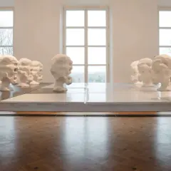Rzędy białych, ekspresyjnych głów, dzieło Wandy Czełkowskiej, tworzą niepokojącą instalację w galerii.