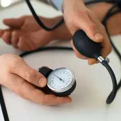 Lekarz mierzy ciśnienie pacjentowi za pomocą ciśnieniomierza. Prenessa czuwa nad jego zdrowiem.