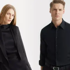 Elegancka kobieta w czarnej stylizacji i mężczyzna w czarnej koszuli, gotowi na ważne spotkanie.
