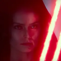 Rey Skywalker w kapturze, z ponurym wyrazem twarzy, trzyma podwójny czerwony miecz świetlny.