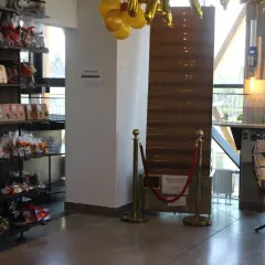 Wnętrze pijalni czekolady w Sanoku. Półki uginają się pod ciężarem słodkości, a złote balony zapowiadają wyjątkowe okazje.
