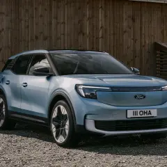 Blå elbil, en Ford Explorer, laddas vid en laddbox framför ett trähus. En spännande ford explorer test.