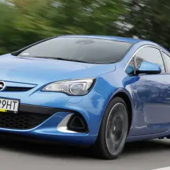 Niebieski Opel Astra G w ruchu, widok z przodu i z boku.