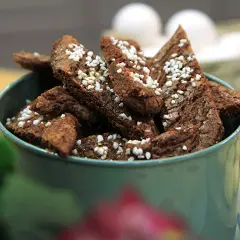 Chokladsnittar recept: Mörka, trekantiga småkakor med pärlsocker i en grön skål. Perfekt för fikat!