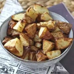 En skål med gyllene, krispiga rostad potatis. Perfekt tillbehör som doftar ljuvligt.