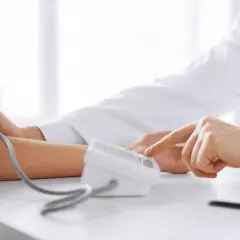 Lekarz mierzy ciśnienie, by sprawdzić, jak obniżyć tętno pacjenta.