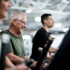 Lächelnder Mann auf Laufband im Fitnessstudio. Er genießt das Training, auch wenn er später sein Widerrufsrecht im Fitnessstudio prüfen muss.