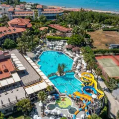 Widok z lotu ptaka na Alba Resort Hotel z basenami, zjeżdżalniami wodnymi, kortami tenisowymi i plażą w tle.