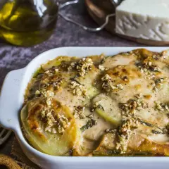 Piatto di patate e formaggio filante, un delizioso pecorino al forno con noci croccanti e erbe aromatiche.