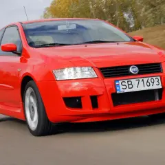 Czerwony Fiat Stilo 1.6 16v w ruchu, z widocznym numerem rejestracyjnym SB 71693.