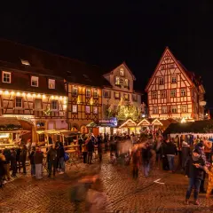 Bunte Lichter und geschäftiges Treiben auf dem **Bad Wimpfen Weihnachtsmarkt**. Fachwerkhäuser und Buden laden zum Verweilen ein.