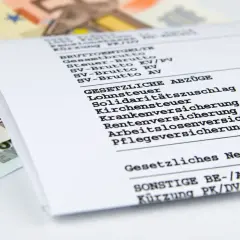 Lohnabrechnung zeigt Brutto und Netto. Ein Anlagenmechaniker fragt sich nach dem anlagenmechaniker gehalt netto. Euroscheine liegen daneben.