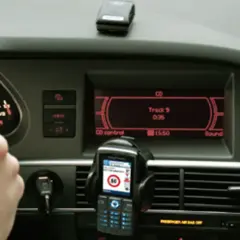 Ręka na kierownicy, telefon z nawigacją i ekran radia w samochodzie. Może to być pomocne, jak odkodować radio.
