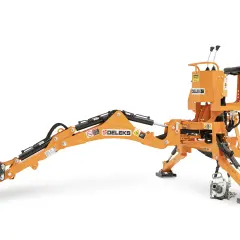 En orange minigrävare, en Delek G1000 vax, redo för arbete. Den har en skopa, arm och förarstol.