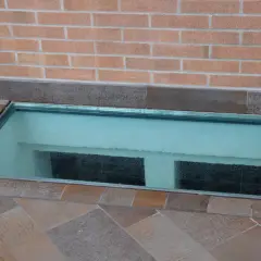 Bocche di lupo come coprirle: una soluzione moderna con una lastra di vetro trasparente che illumina l'interrato.