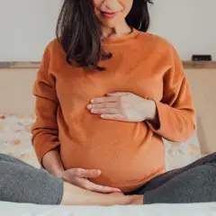Schwangere Frau hält ihren Bauch. Wichtige Nährstoffe wie Vitamin A sind für die Schwangerschaft essenziell.