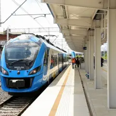 Błękitny pociąg EN63A-038 na stacji Szczecin Turzyn. Ludzie czekają na peronie, gotowi do podróży, być może do Łodzi.
