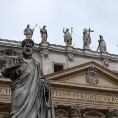 Kamienna postać z kluczem w dłoni, na tle bazyliki. Czy mantry są niebezpieczne? Ta rzeźba nie daje odpowiedzi.