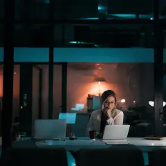 Kobieta pracuje po godzinach, zastanawiając się, czy pracodawca może zmusić do nadgodzin.