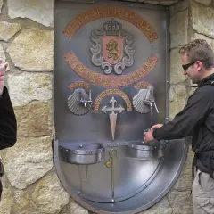 Peregrinos en el Camino de Santiago se refrescan en la fuente del vino y agua de Irache.