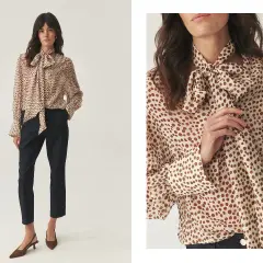Elegancka koszula damska w groszki z kokardą, noszona do ciemnych spodni. Stylowa propozycja, jak nosić koszulę damską do spodni.