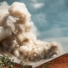 Dichter Rauch steigt aus einem Gebäude auf, ein Zeichen für eine laufende mechanische entrauchung.