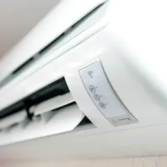 Un moderno aire acondicionado blanco con iconos de Wi-Fi y temperatura. El significado del aire acondicionado es confort y bienestar en el hogar.
